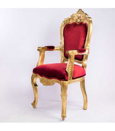 Golden and red velvet baroque-style armchair positioned in a white setting