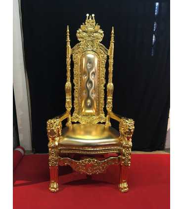 Imperial-style gilded baroque throne, carved gilded wood frame, high backrest, placed on a red carpet.