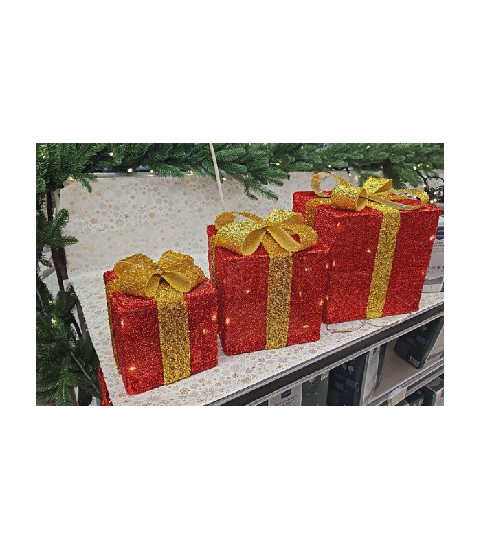 Set de 3 boîtes cadeaux LED disposées sur une table lors d’une décoration de Noël avec sapin en arrière-plan.