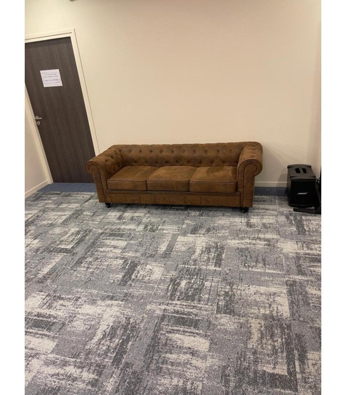 canapé Chesterfield marron en tissu dans une salle