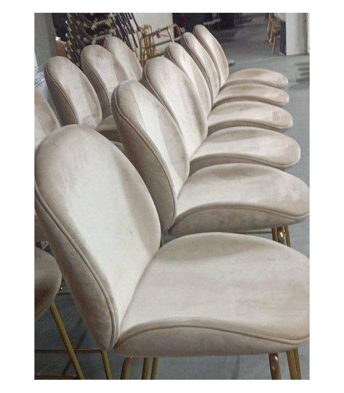 Tabourets de bar métal doré et tissu écru alignés dans une salle événementielle