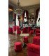 Castle salon furnished with red velvet barrel chairs, poufs and pedestal tables under a chandelier, 126 Events