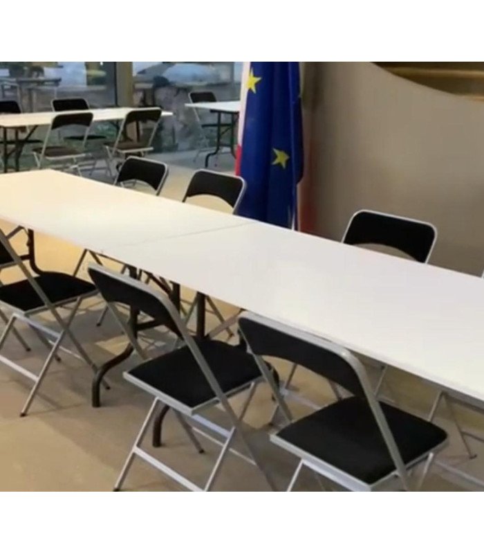 Table pliante rectangulaire 180 cm x 80 cm installée dans une salle de réunion avec plusieurs chaises