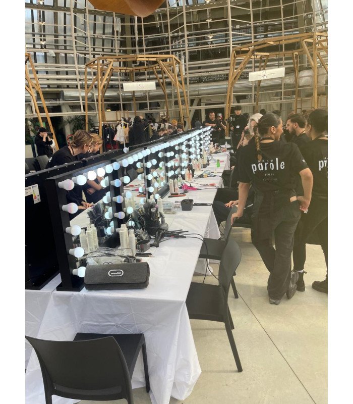 plusieurs miroirs led à maquillage installés dans une grande salle de préparation