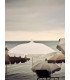 White parasol with frills on a beach