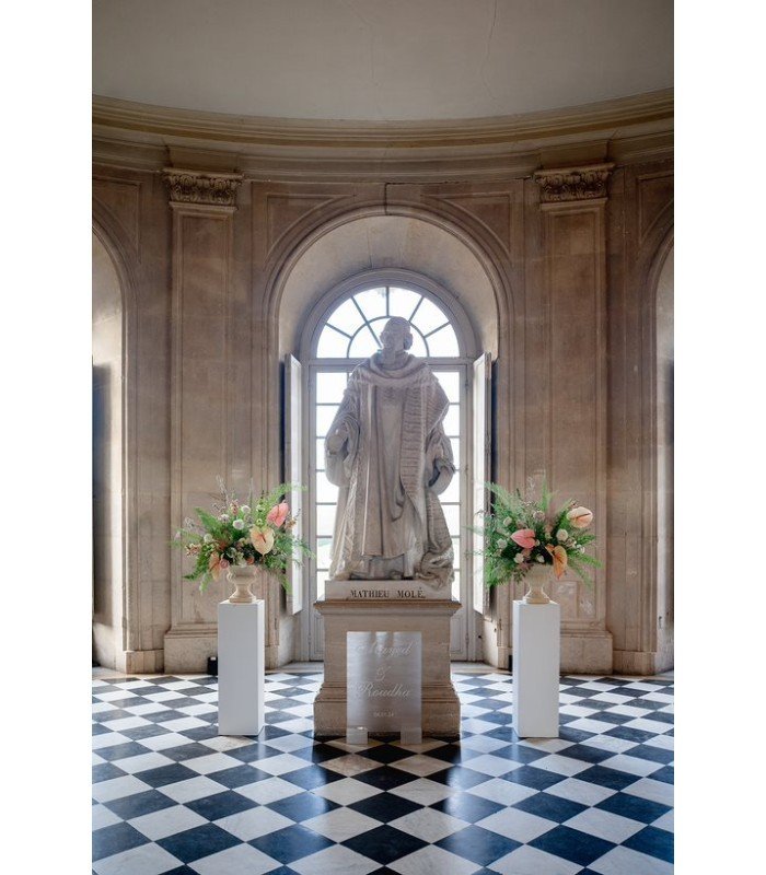 White stele with bell H 110 cm used as statue support with bouquet of flowers