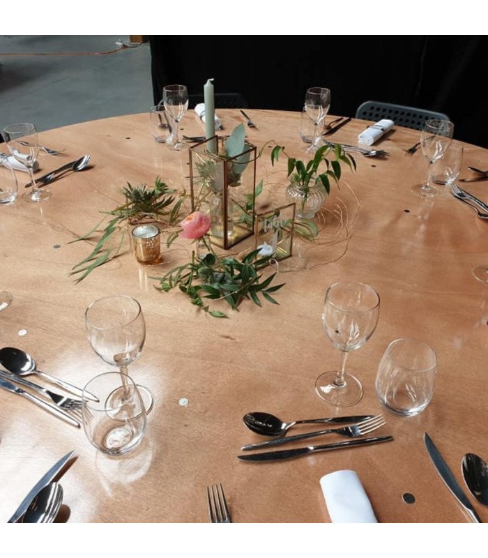 Table ronde pliante en bois 168 cm décorée avec plantes, bougies, couverts et verres pour un repas de réception