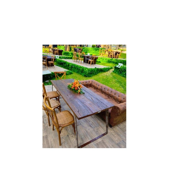 canapé Chesterfield marron vieilli avec table basse et chaises dans un jardin pour événement en extérieur