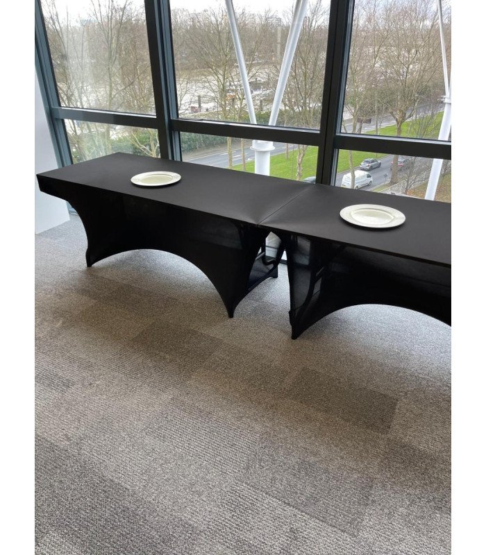 Buffet line of black stretch table covers with white plates in a corporate space, 126 Events
