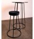Tabouret haut en métal noir avec coussin en velours beige près d’une table haute assortie