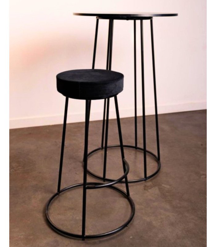 Tabouret haut en métal noir avec coussin en velours beige près d’une table haute assortie