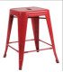 Tabouret bas rouge en métal de style industriel sur fond blanc