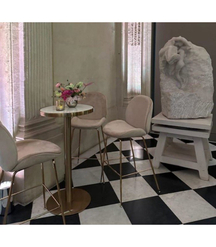 Mange-debout Gatsby métal or accompagné de trois chaises hautes et d’une sculpture décorative
