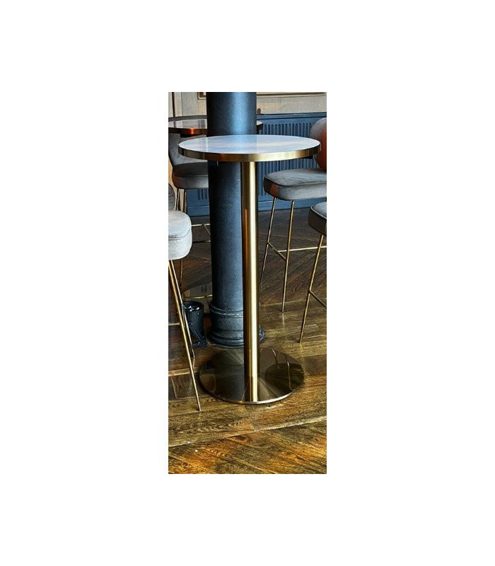 A gold metal Gatsby bar table paired with a black bar stool in a bar area