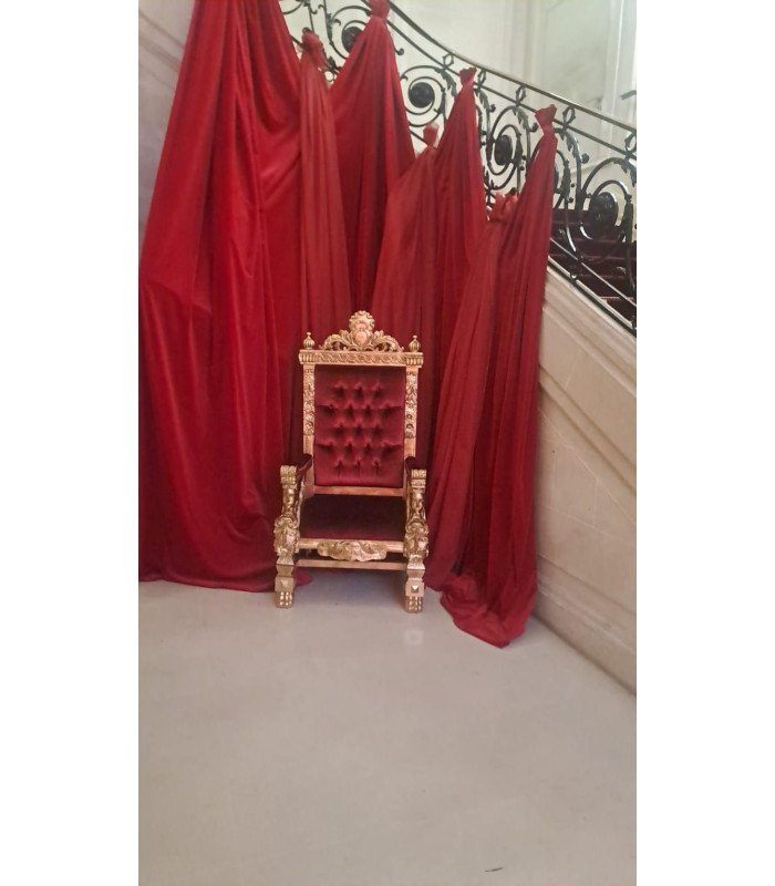 Trône baroque rouge et or modèle Elizabeth installé dans un château, décor rouge.