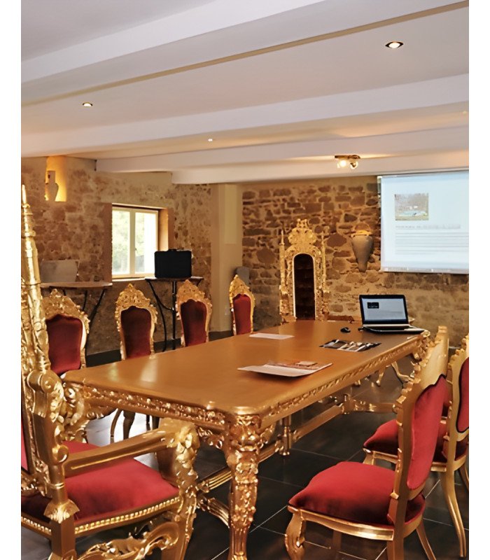 Two thrones in gilded wood and red velvet around a large gilded table in a reception room