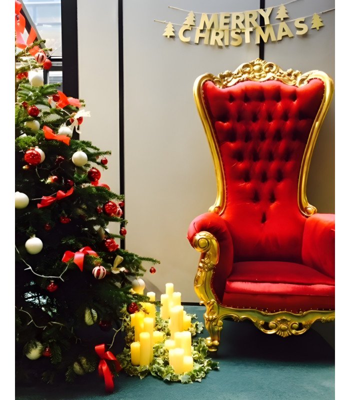 Golden and red princess throne next to a Christmas tree under a Merry Christmas sign