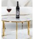 Gold-toned coffee table with marble-effect top, paired with a sofa and rug.