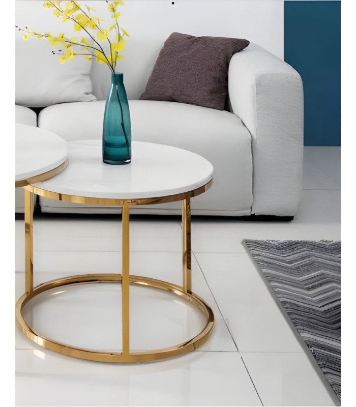 Gold-colored coffee table with marble-effect top, placed in a living room with a sofa and rug.