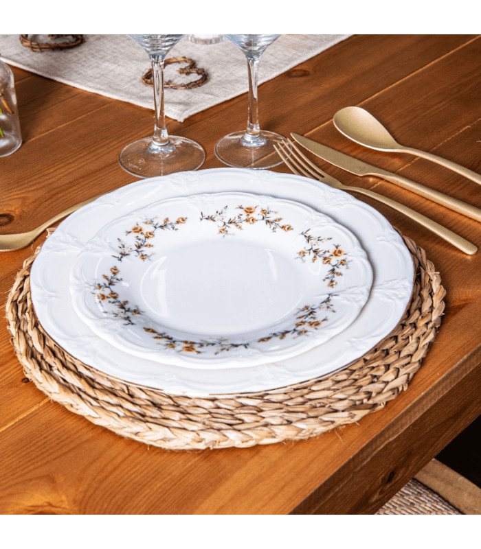 Assiette plate motif fleurs Ø 21 cm dressée sur table avec couverts et verre pour réception