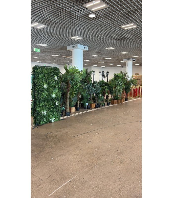 Cloisons végétales artificielles vertes utilisées pour séparer des stands sur un salon professionnel