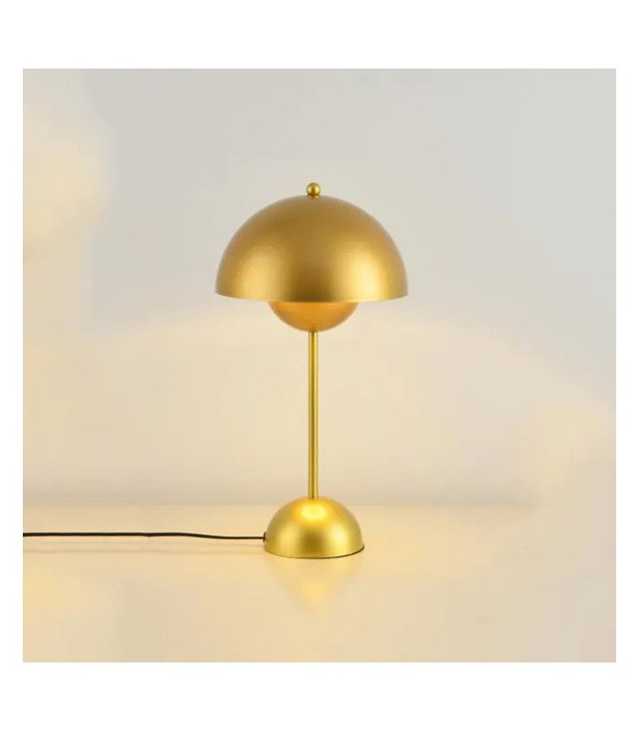 Petite lampe dorée moderne minimaliste en métal posée près d’un mur