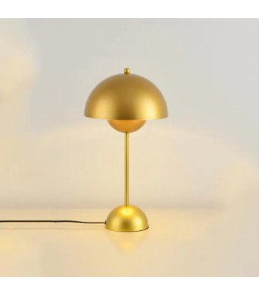 Petite lampe dorée moderne minimaliste en métal posée près d’un mur