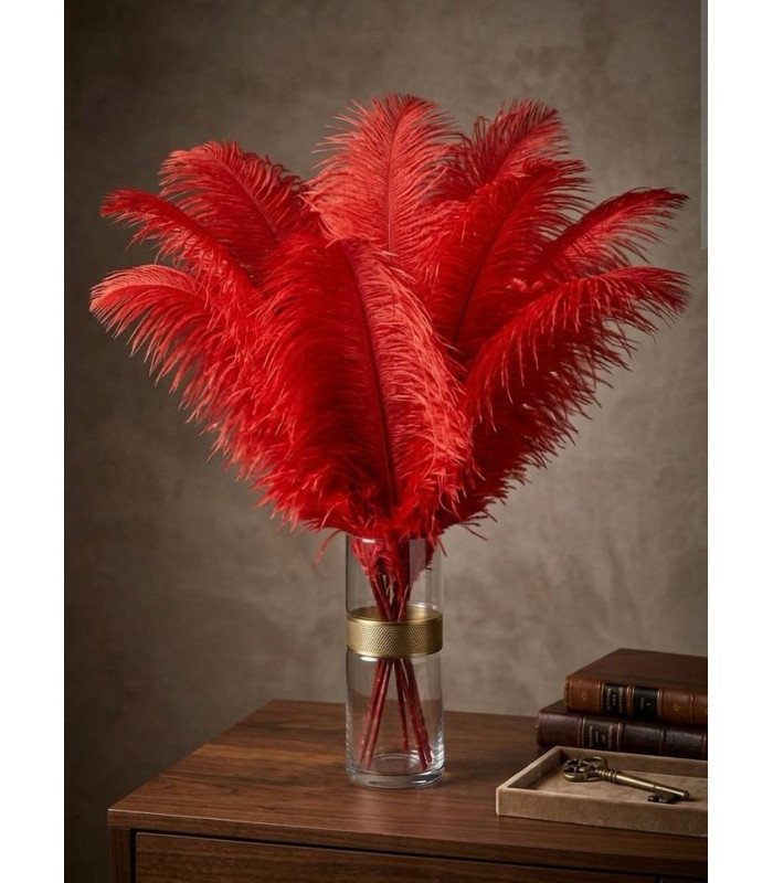 A bouquet of red ostrich feathers in a glass vase on a lounge coffee table.