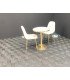 Chaise scandinave beige en velours avec pieds dorés autour d’une table ronde dans un espace café