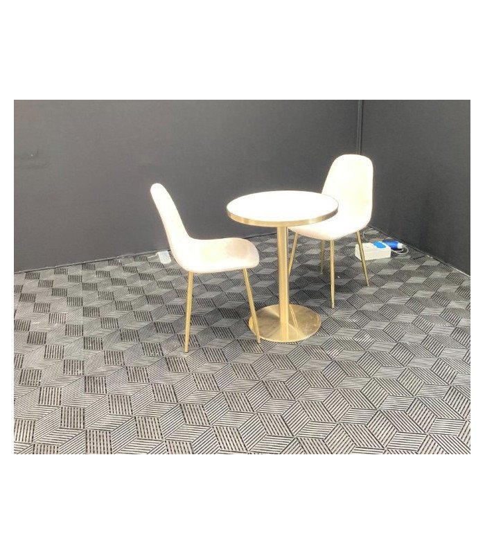 Chaise scandinave beige en velours avec pieds dorés autour d’une table ronde dans un espace café