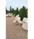 Versailles round sofas in beige fabric and whitewashed wood, set up in a garden