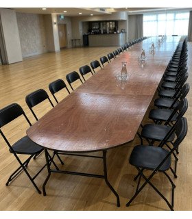 Wooden conference table for 20 with rounded ends and black folding chairs, rental by 126 Events in Paris